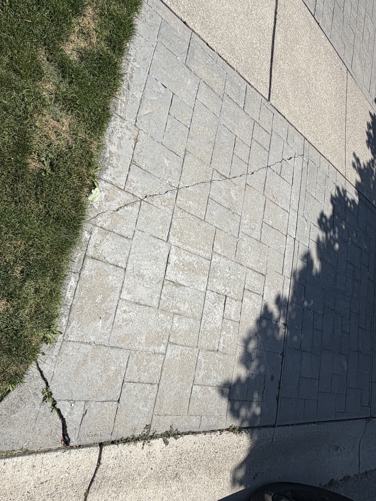 Cracked, faded stamped concrete walkway before repair