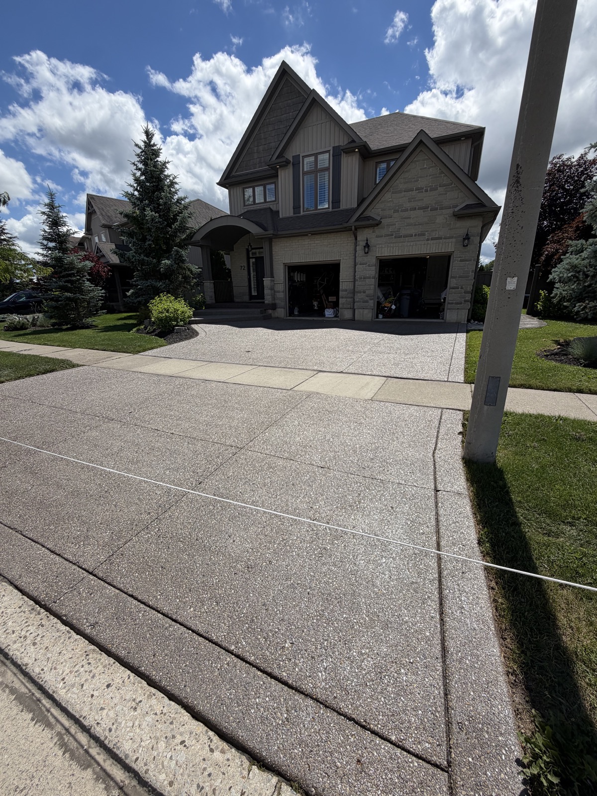 Exposed-aggregate driveway after a deep clean and high-gloss seal